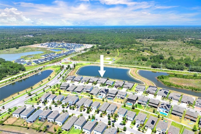 birds eye view of property featuring a water view and a view of trees