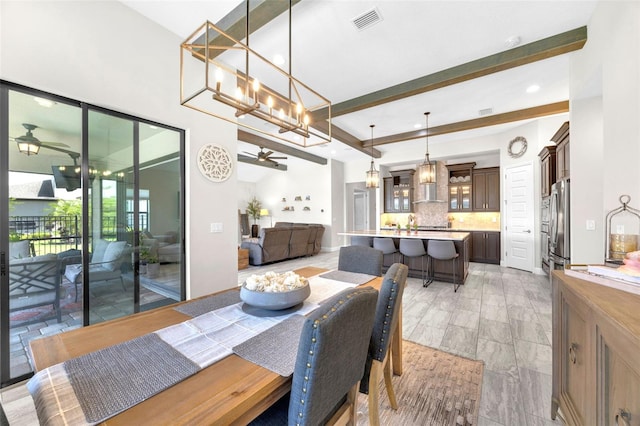 dining room featuring a healthy amount of sunlight, visible vents, ceiling fan with notable chandelier, and beam ceiling