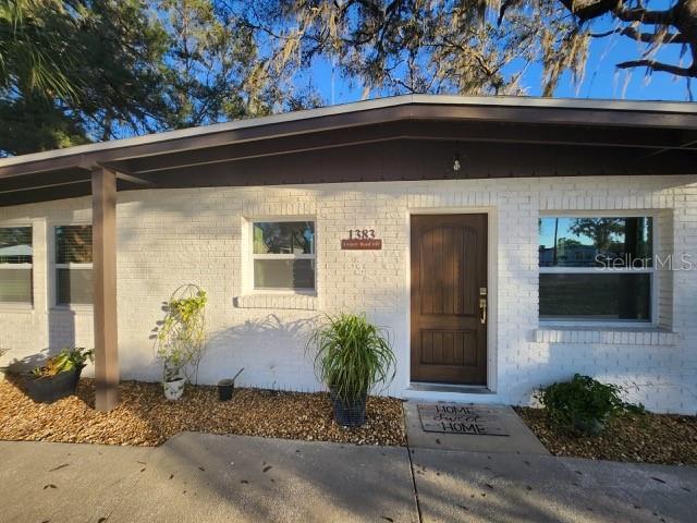 property entrance featuring brick siding