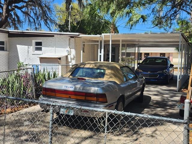 view of car parking with a carport and a fenced front yard