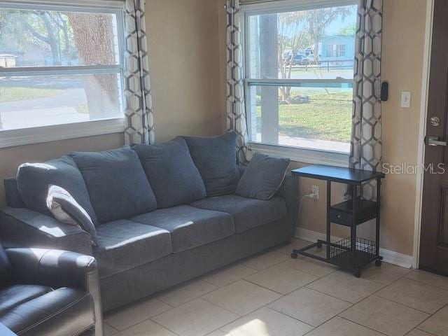 living area with light tile patterned floors and baseboards