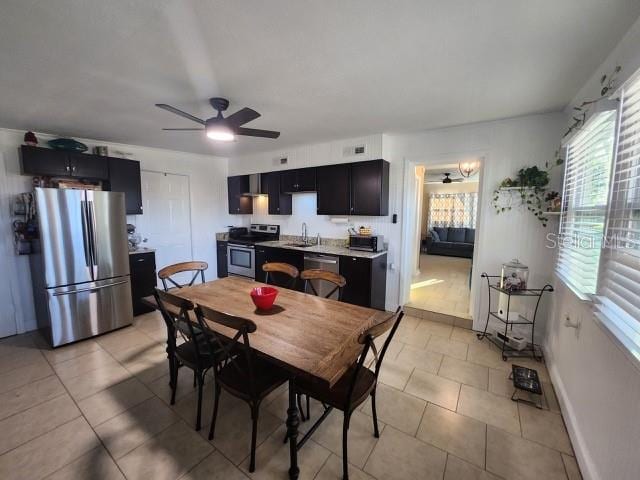 dining room featuring light tile patterned floors, a ceiling fan, and baseboards