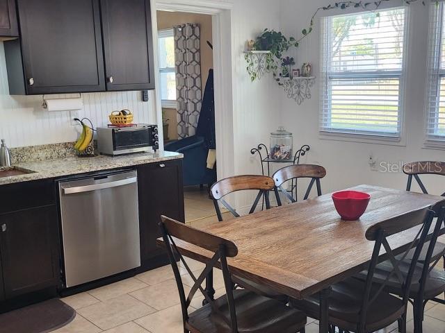 dining area with light tile patterned floors, plenty of natural light, and a toaster