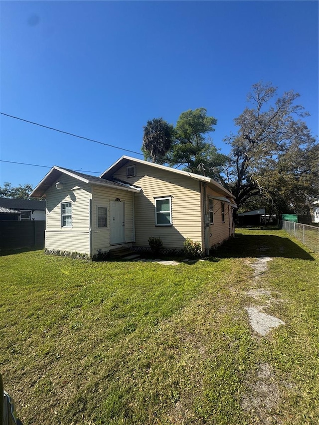 view of front of property with driveway, a front lawn, and fence