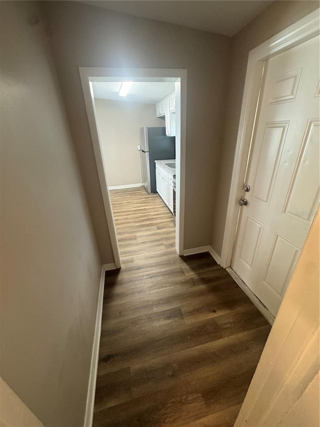 hall featuring wood finished floors and baseboards