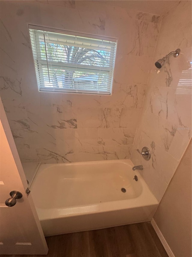 bathroom with shower / bathing tub combination and wood finished floors