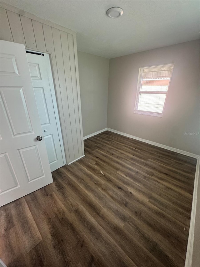 unfurnished room featuring dark wood finished floors and baseboards