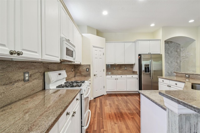 kitchen with white cabinetry, white appliances, recessed lighting, and light wood-style floors