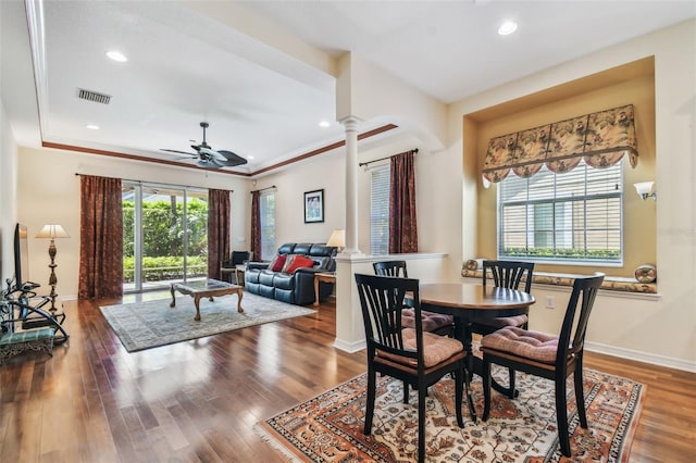 dining space with visible vents, ceiling fan, wood finished floors, plenty of natural light, and ornate columns