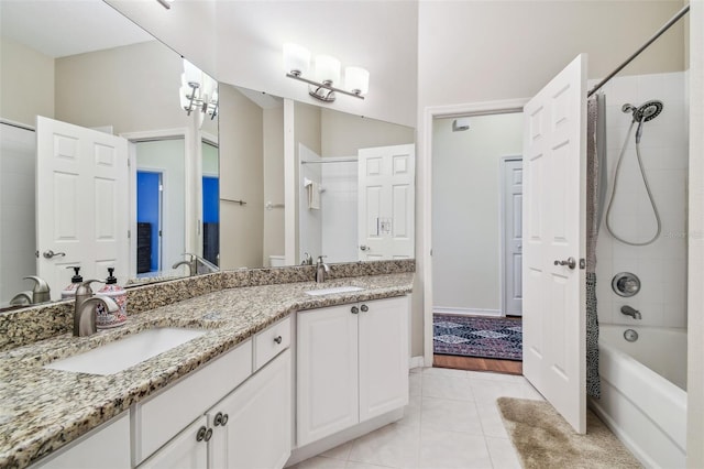 full bathroom with tile patterned floors, double vanity,  shower combination, and a sink