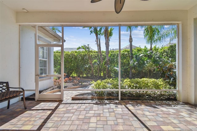 unfurnished sunroom with ceiling fan