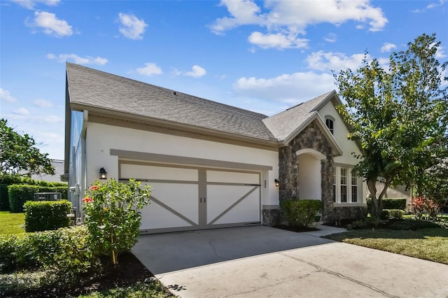 view of front of house featuring stone siding, stucco siding, an attached garage, and concrete driveway