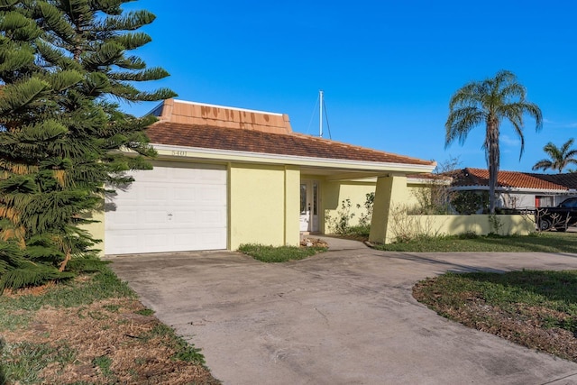 view of front of property with a garage, driveway, and stucco siding