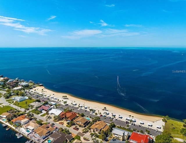 drone / aerial view with a residential view, a water view, and a beach view