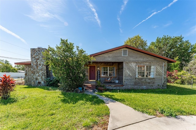 view of front of property with a front yard, fence, and covered porch