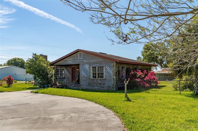 bungalow-style house featuring a front yard and fence