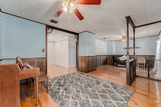 interior space with visible vents, wainscoting, wallpapered walls, and a ceiling fan