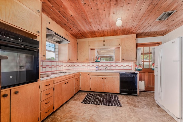 kitchen featuring visible vents, under cabinet range hood, tile countertops, black appliances, and a sink