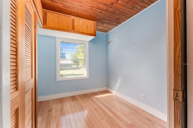 unfurnished bedroom featuring light wood finished floors, a closet, wood ceiling, and baseboards
