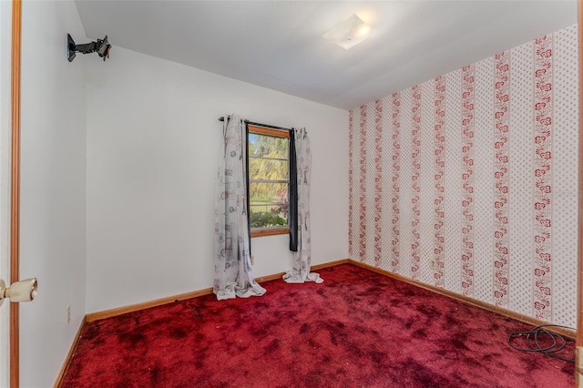 carpeted empty room featuring baseboards