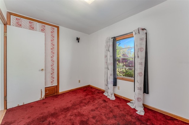 spare room featuring baseboards and carpet