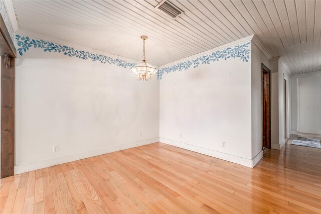 empty room featuring visible vents, a notable chandelier, wood finished floors, crown molding, and wood ceiling