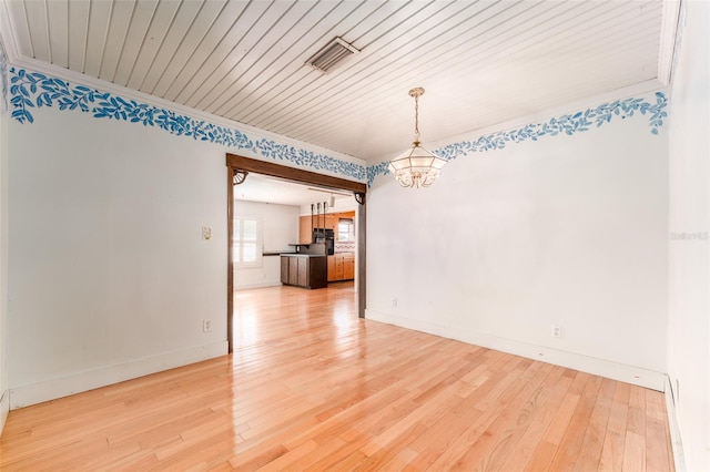 unfurnished room with visible vents, baseboards, light wood-style floors, and a chandelier