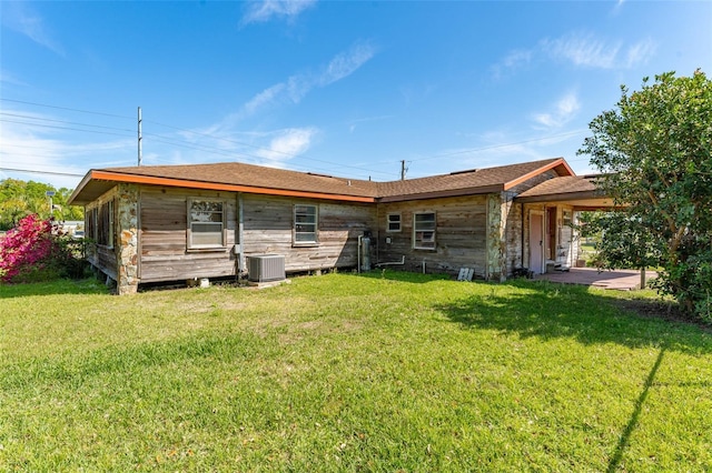 back of house with a yard and central AC