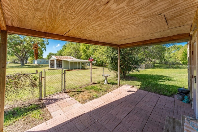 view of patio featuring an outbuilding, a gate, and fence