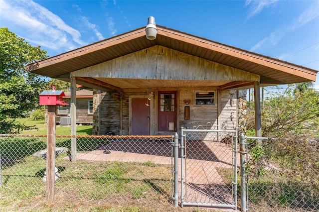 view of front of house featuring a porch, fence, and a gate