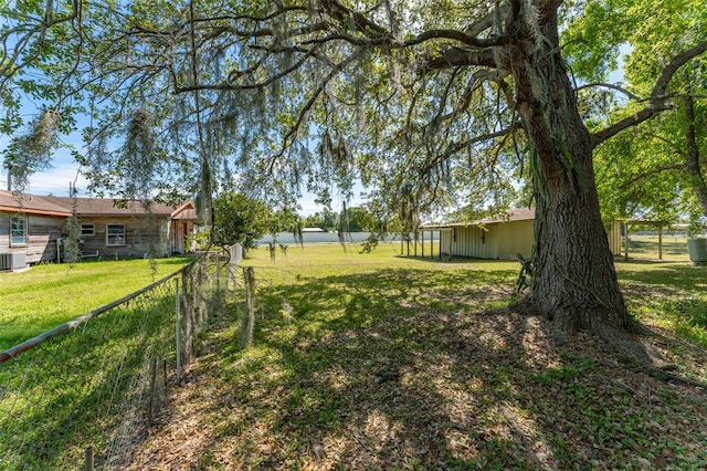 view of yard featuring an outbuilding and fence