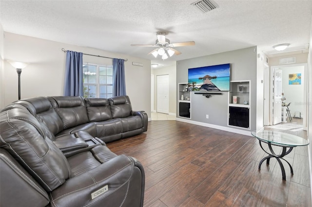 living room with wood finished floors, baseboards, visible vents, ceiling fan, and a textured ceiling