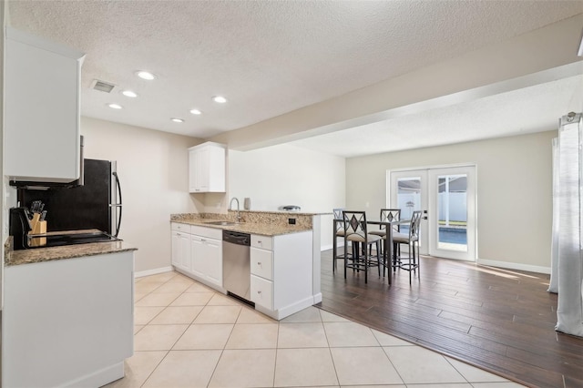 kitchen featuring visible vents, a peninsula, a sink, french doors, and stainless steel dishwasher