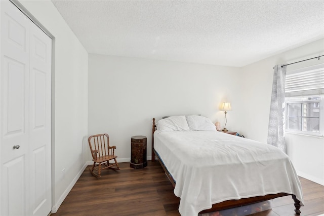 bedroom featuring a textured ceiling, baseboards, and wood finished floors