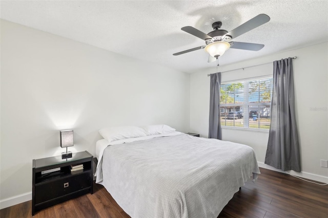 bedroom with a ceiling fan, wood finished floors, baseboards, and a textured ceiling