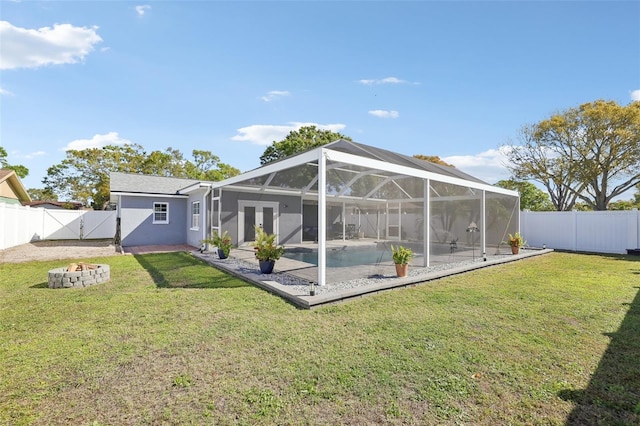 back of house featuring a gate, glass enclosure, a fenced backyard, and stucco siding