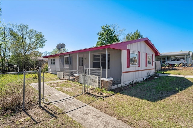 manufactured / mobile home with a front lawn, a gate, and fence