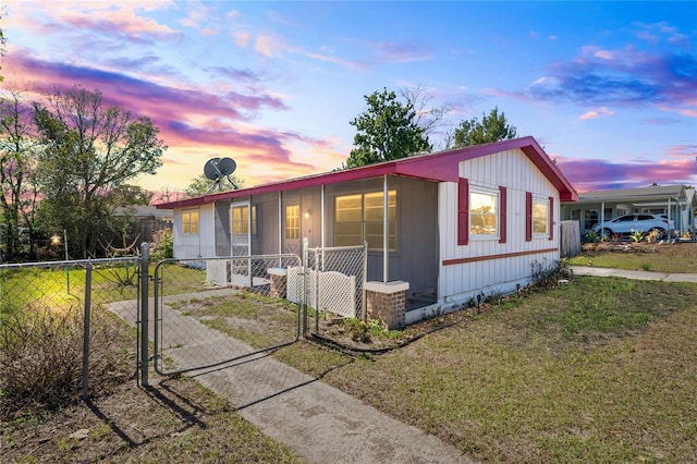 view of front of house with a carport, fence, a front yard, and a gate