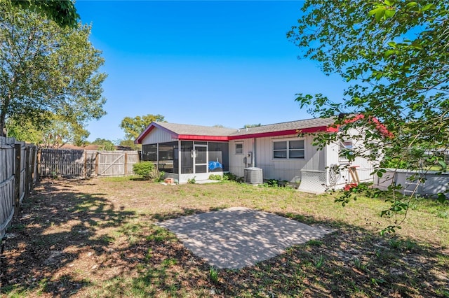 back of house featuring a yard, central air condition unit, a fenced backyard, and a sunroom