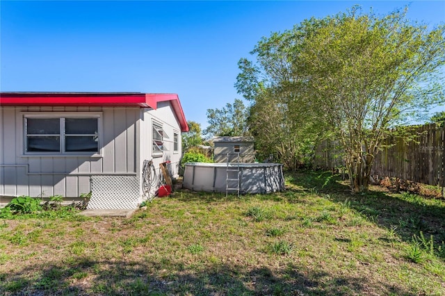 view of yard with fence and an outdoor pool