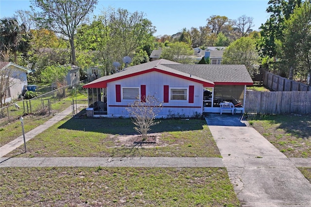 bungalow-style home with a carport, concrete driveway, a front yard, and fence