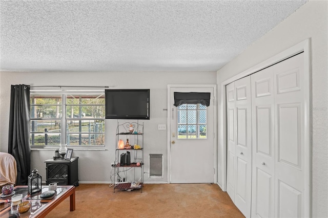 living area featuring a textured ceiling and carpet flooring