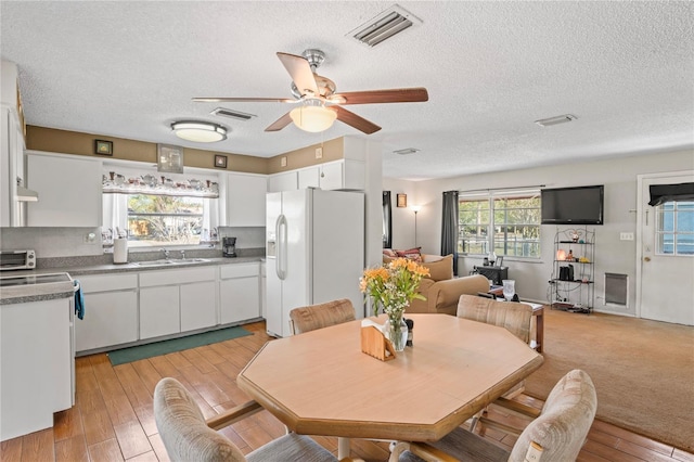 dining area with a wealth of natural light, visible vents, and a ceiling fan