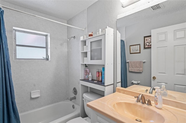 bathroom with visible vents, toilet, vanity, shower / bath combination with curtain, and a textured ceiling