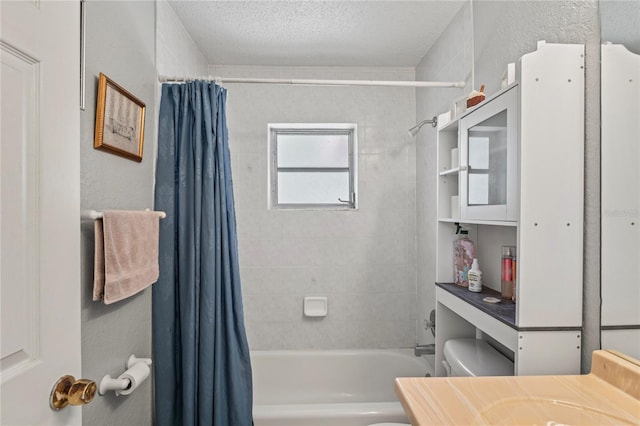 full bath with toilet, shower / tub combo, a textured wall, a textured ceiling, and vanity