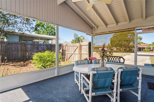 sunroom featuring vaulted ceiling with beams and a ceiling fan