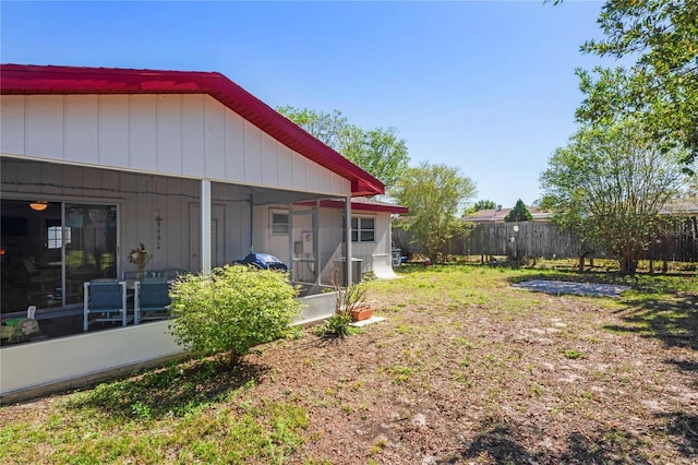 view of yard with fence and a sunroom