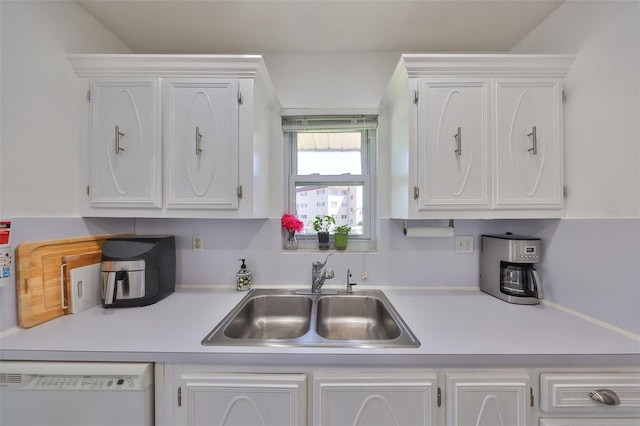 kitchen featuring dishwasher, white cabinetry, and a sink