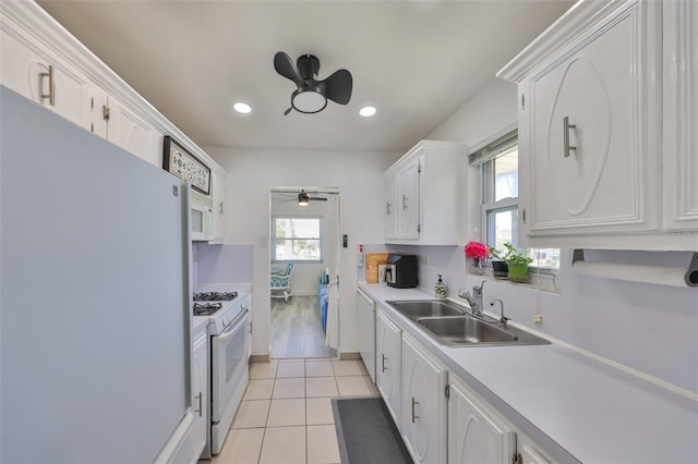 kitchen with ceiling fan, light tile patterned flooring, white cabinets, white appliances, and a sink