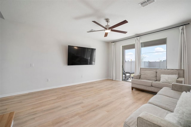 living area featuring visible vents, baseboards, light wood-type flooring, and ceiling fan